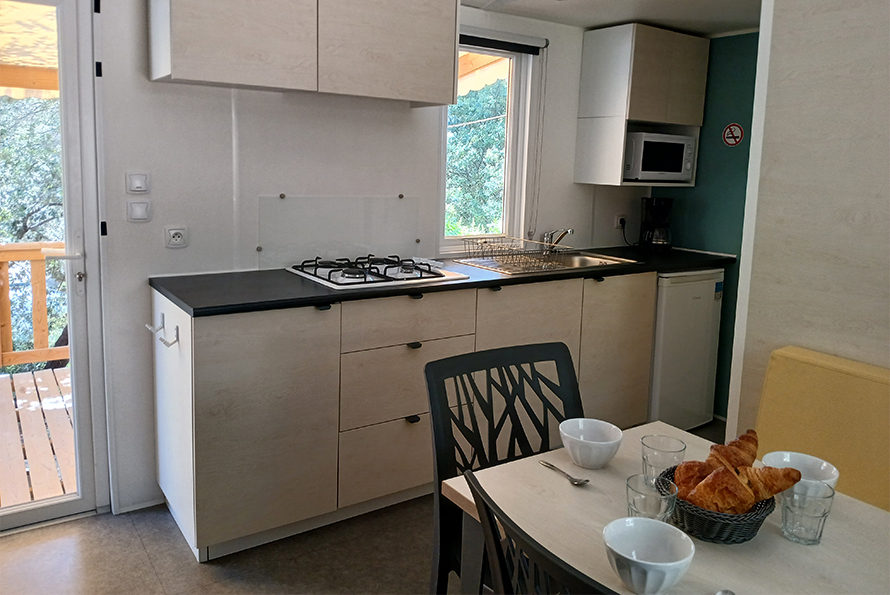 Kitchen and dining area in the mobile home to rent for 4 to 6 people at the Cézanne Sainte-Victoire campsite in Puyloubier